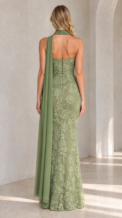 Back view of sage green strapless evening gown highlighting fit and long drape