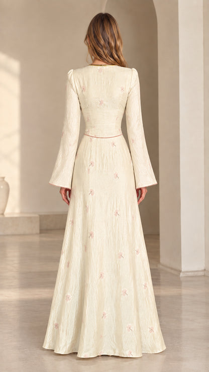 Back view of model wearing cream floral jacquard bell sleeve maxi dress
