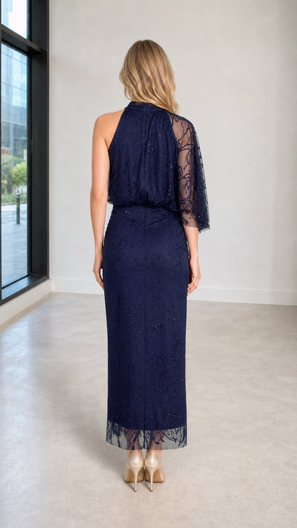 Back view showing asymmetrical capelet detail on Navy dress