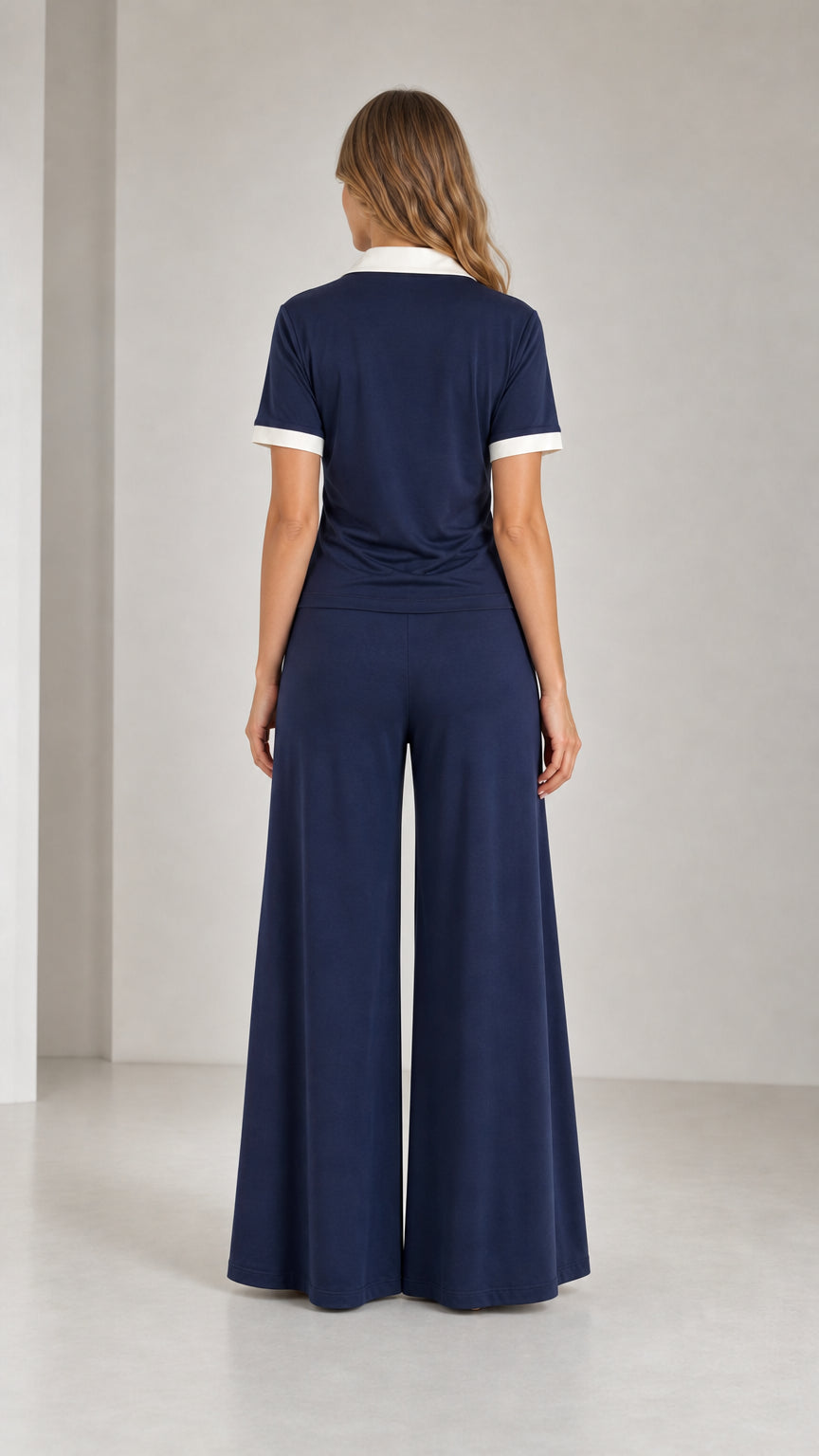 Back view of model wearing Navy Blue polo and wide leg pants two-piece set