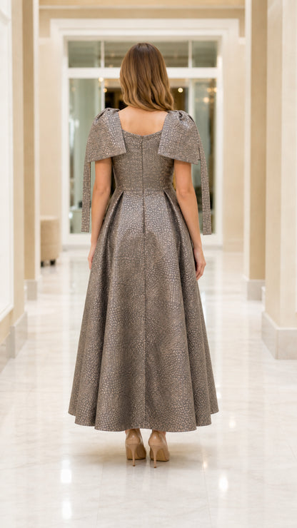 Back view of model in Charcoal Taupe formal dress showing square back and pleated skirt