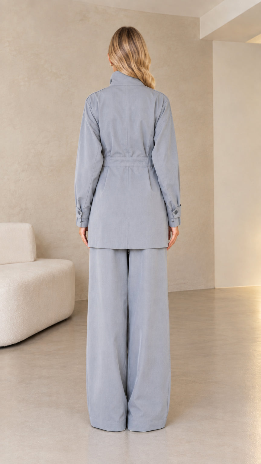 Back view of dusty blue longline utility jacket and wide trousers