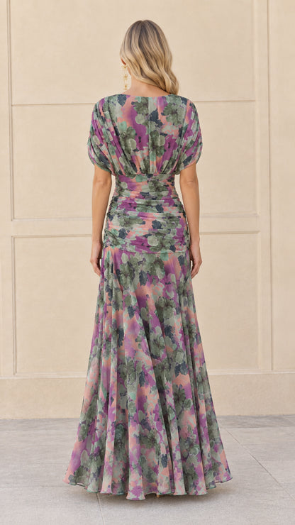 Back view of woman in sage purple floral printed chiffon maxi gown