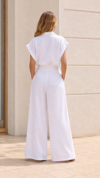 Back view of woman wearing white jumpsuit