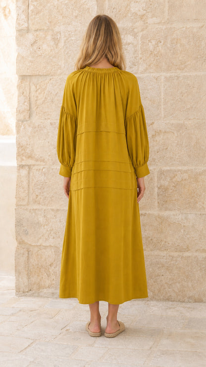 Full back view of model in mustard tiered maxi dress