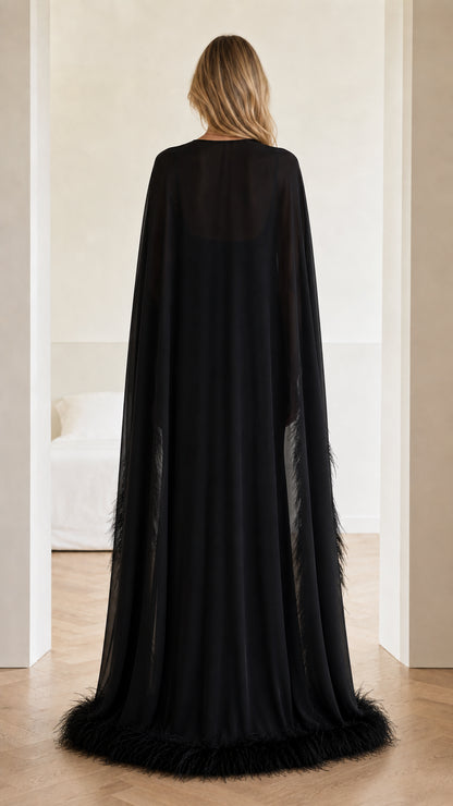 Back view of floor-length black sheer cape evening gown