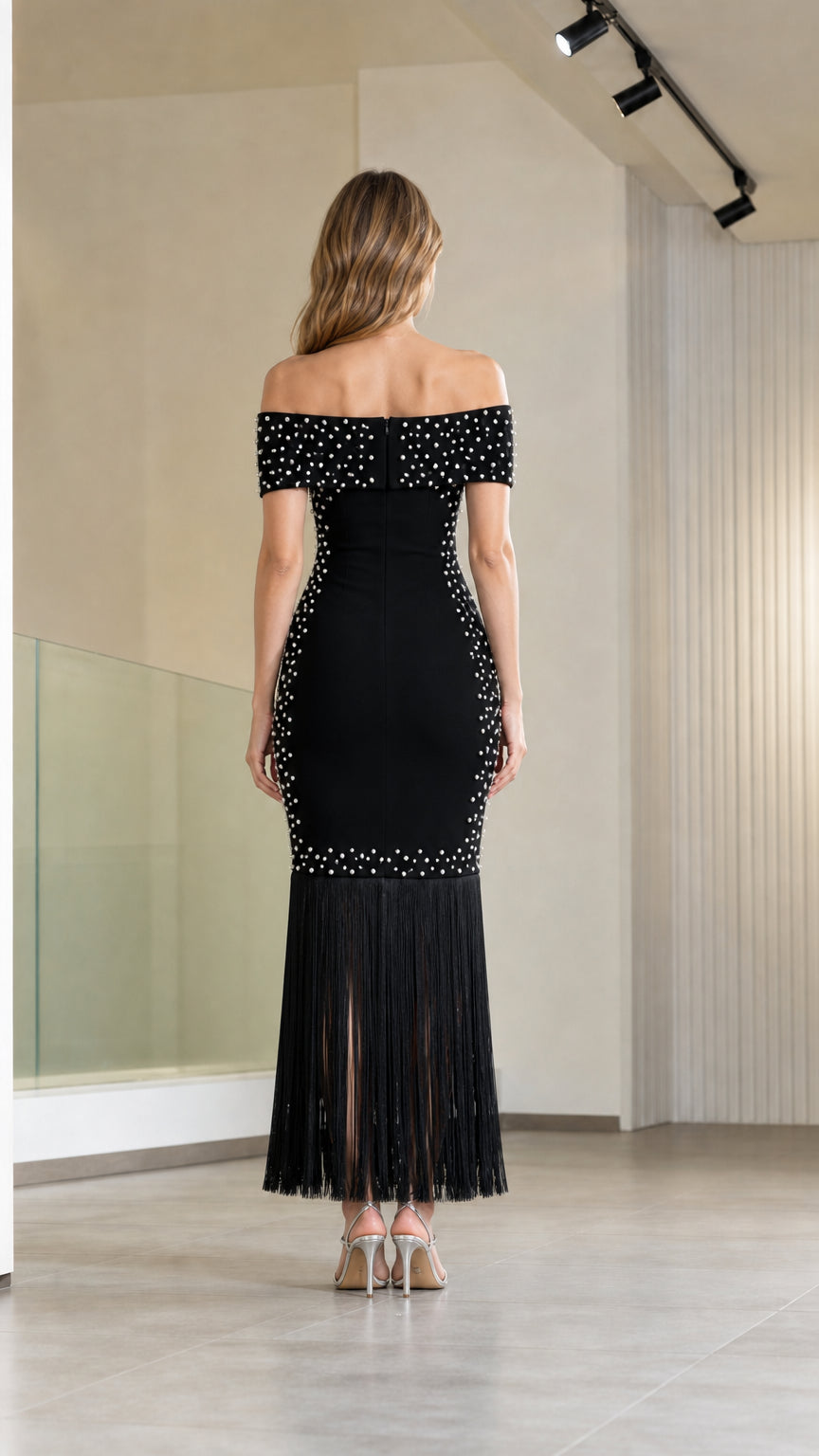 Back view of model wearing black off-the-shoulder pearl beaded evening gown