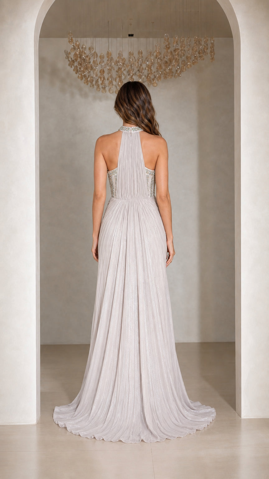 Back view of Silver pleated halter evening gown showing open shoulders and sweeping train
