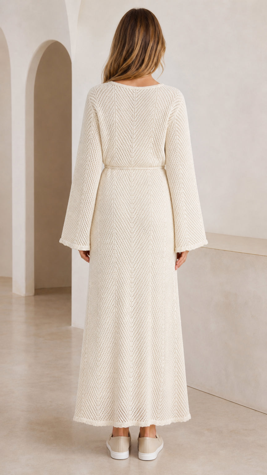 Back view of model wearing full-length cream knit dress