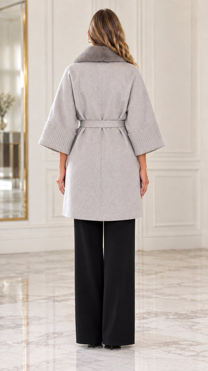 Back view of model showcasing the tailored fit of the light grey belted coat