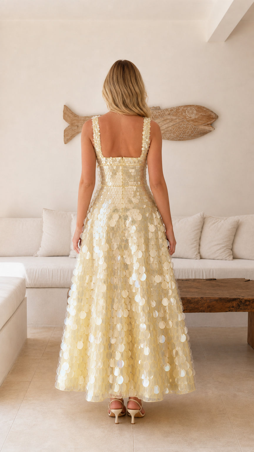 Back view of model wearing a champagne sequin sleeveless maxi dress with square back