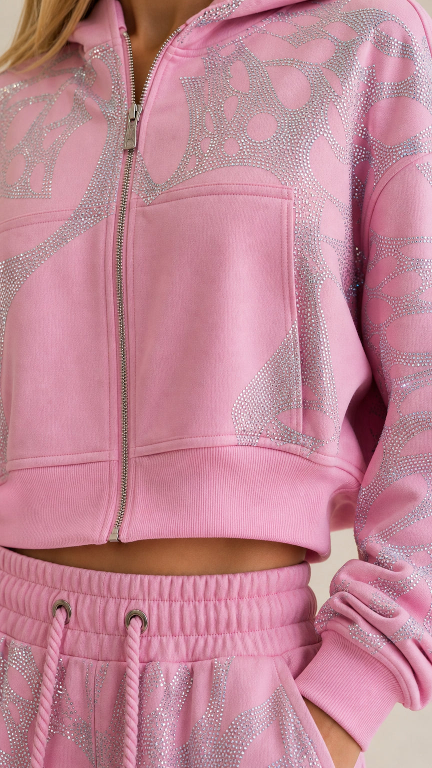 Close-up detail of zipper, fabric texture, and rhinestone pattern on pink hoodie and waistband