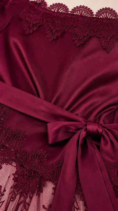 Close up detail of burgundy satin bodice lace trim and waist tie ribbon