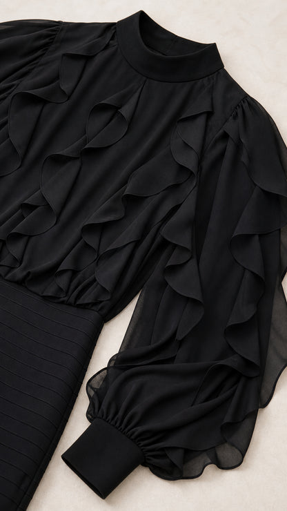 Close-up detail of mock neck, bodice ruffles, and banded cuffs on black dress
