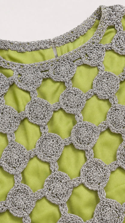 Close-up detail of silver metallic circular crochet pattern and lime green lining