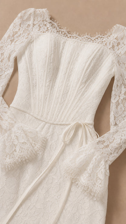 Close-up detail of white lace neckline, pleated bodice, and flared cuffs
