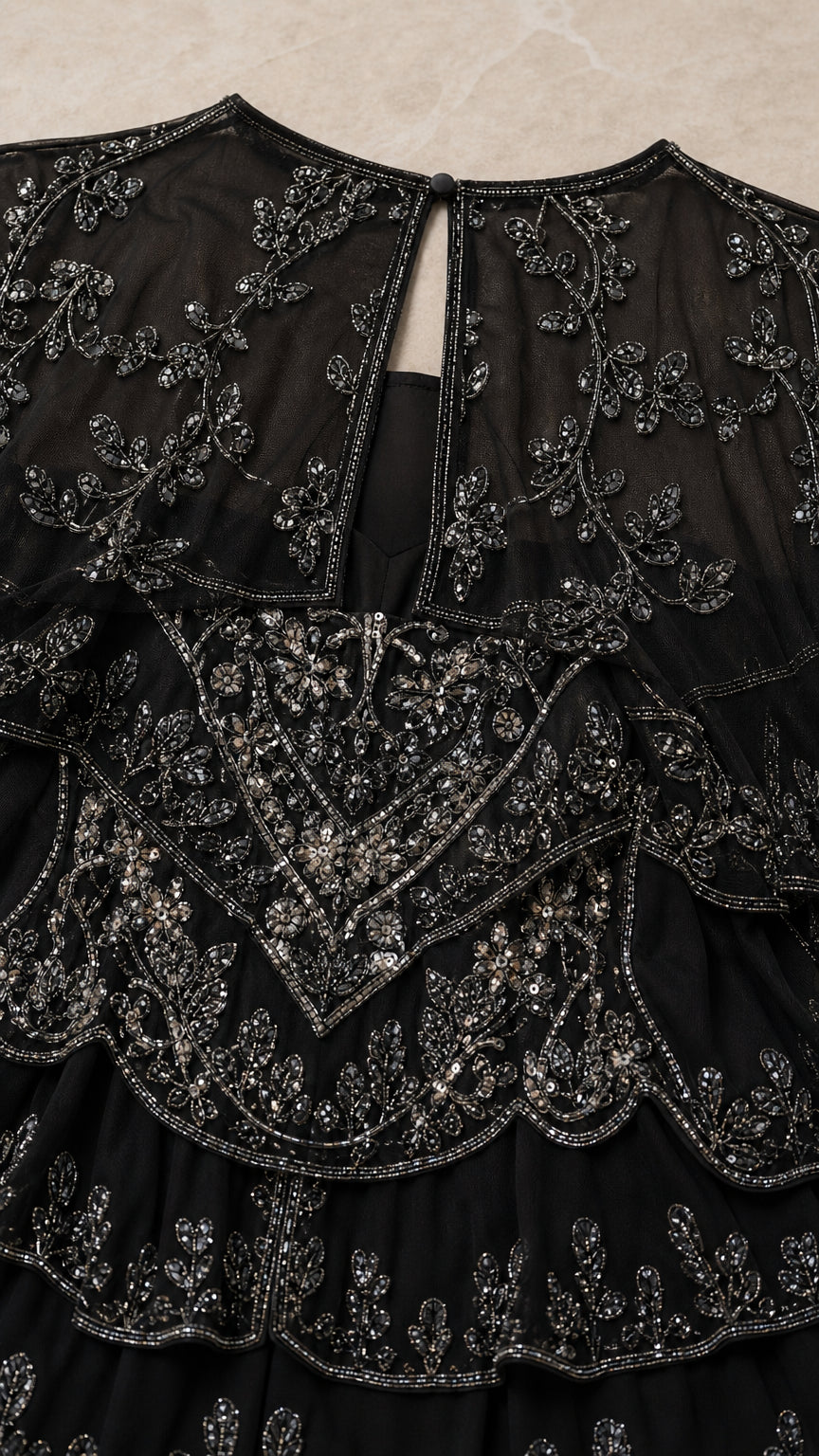 Detailed close-up of intricate black beading, sequins, and back keyhole closure