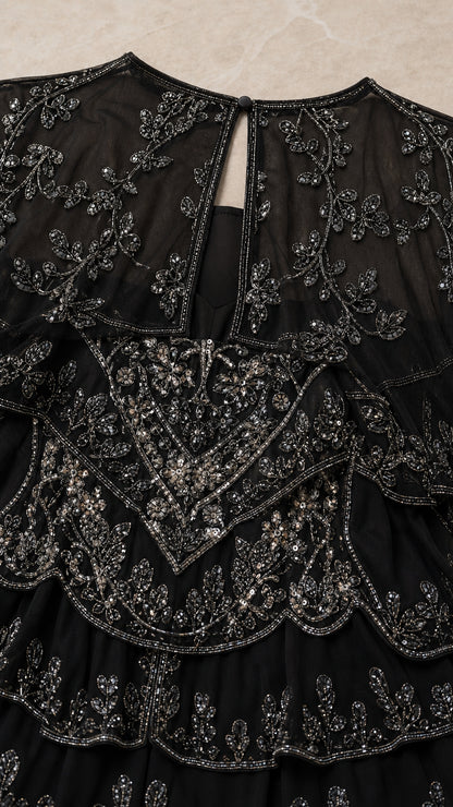 Detailed close-up of intricate black beading, sequins, and back keyhole closure