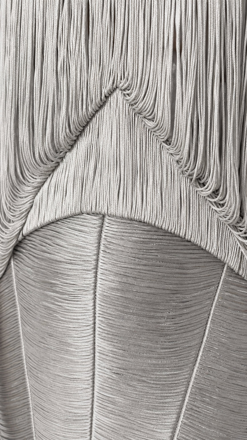 Close-up detail of textured layered fringe construction on dress bodice