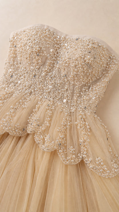 Close-up detail of intricate pearl and bead embellishments on peplum bodice