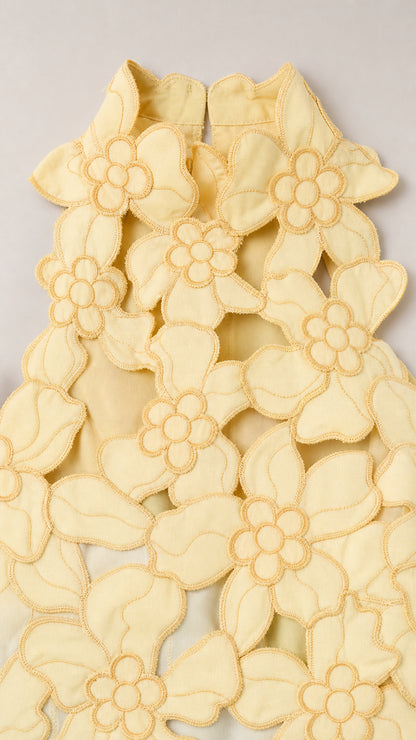 Close-up detail of Yellow floral laser-cut fabric pattern