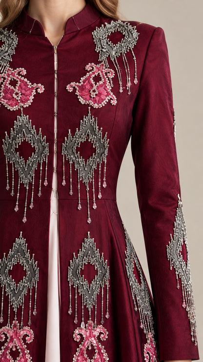 Close-up detail of intricate embroidery and beaded fringe on burgundy evening dress