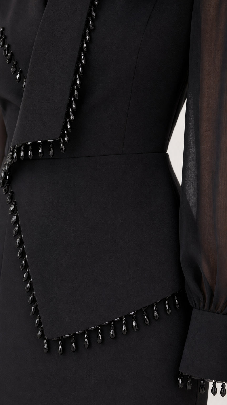 Close-up detail of black beaded fringe trim on lapel and sleeve cuff