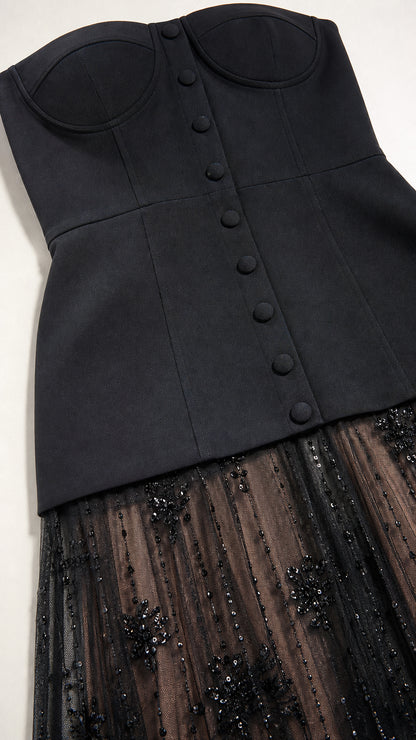 Close-up detail of structured black sweetheart bustier with covered buttons and sequined mesh