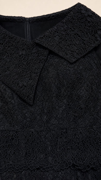 Close-up detail of textured floral lace fabric and structured folded neckline