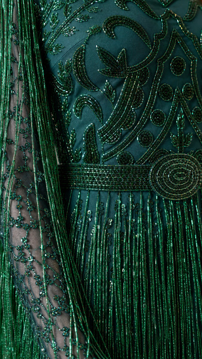 Close-up detail of bodice embroidery and fringe on emerald gown