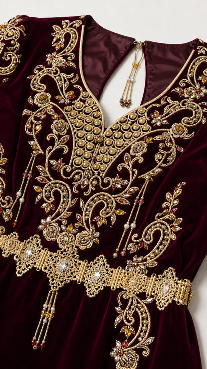 Close-up detail of ornate gold metallic embroidery and beadwork on burgundy velvet