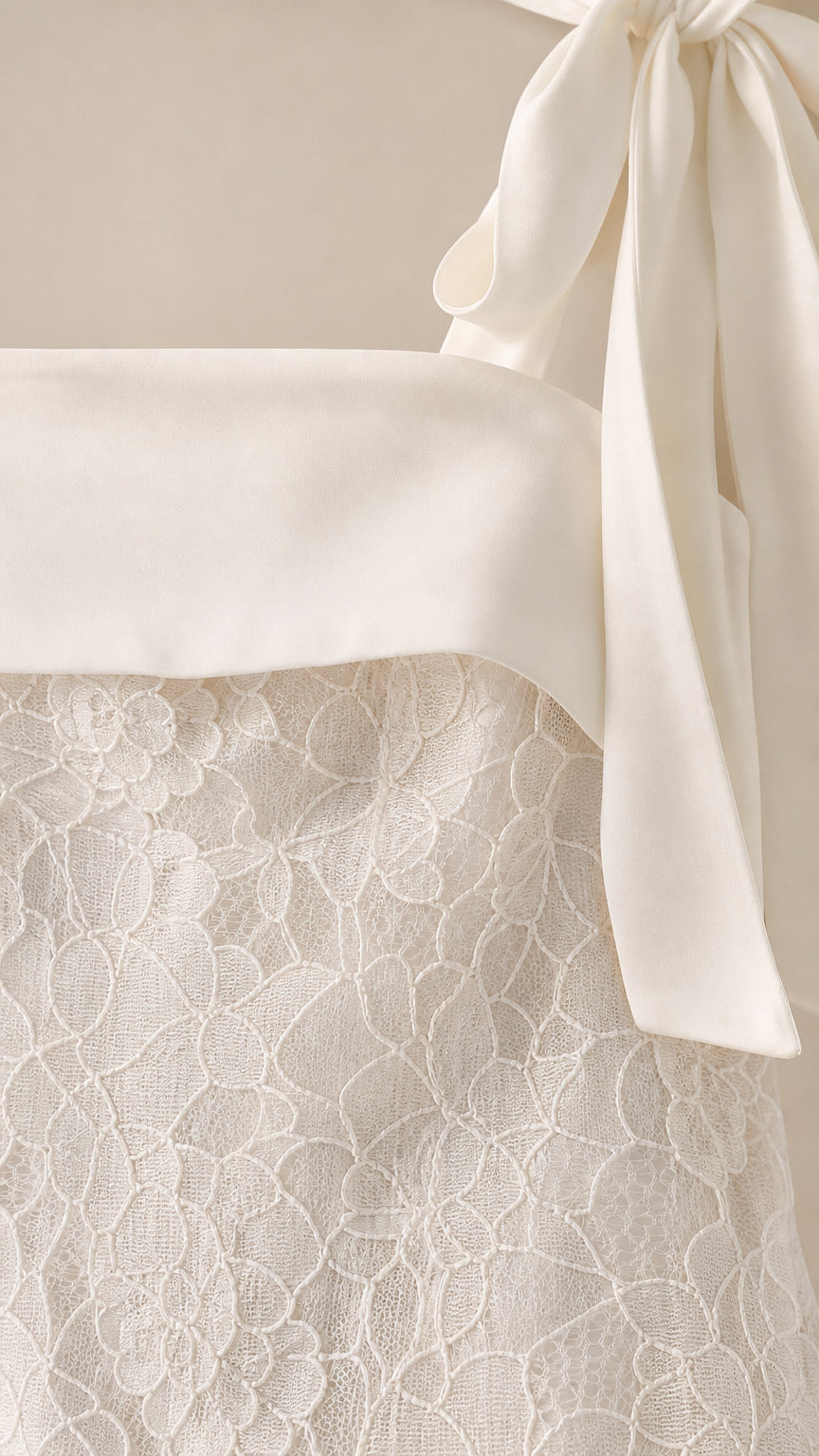 Close-up detail of lace texture and shoulder bow