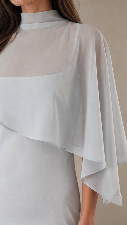 Close up of sheer cape overlay and mock neck detail