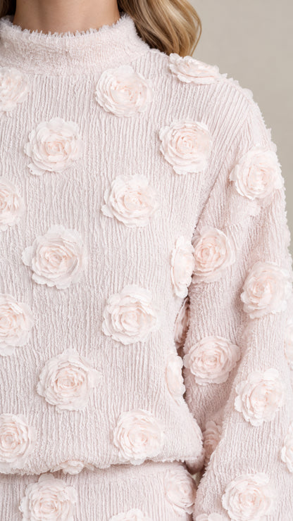 Close-up detail of textured crinkle fabric and 3D floral rosette embellishments in Blush Pink