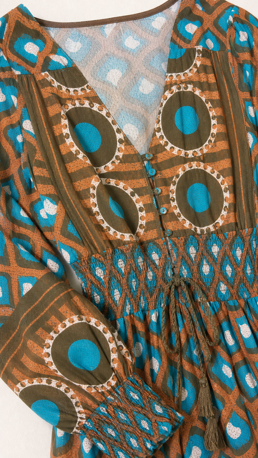 Close-up detail of neckline, smocked waist, and geometric pattern on Teal Brown dress