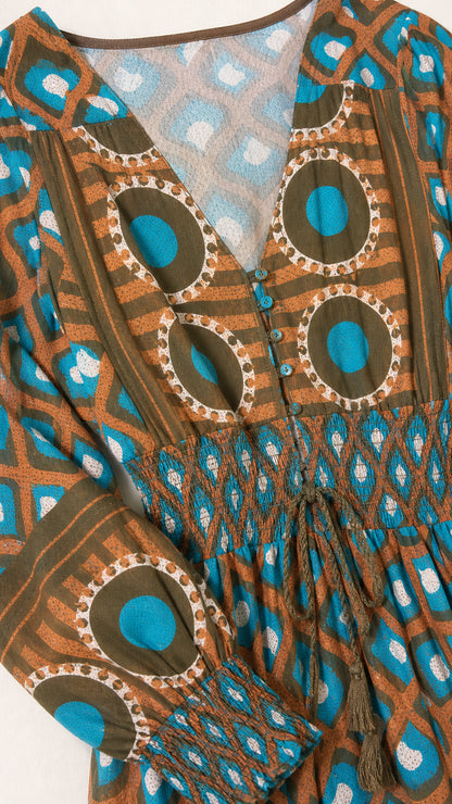 Close-up detail of neckline, smocked waist, and geometric pattern on Teal Brown dress