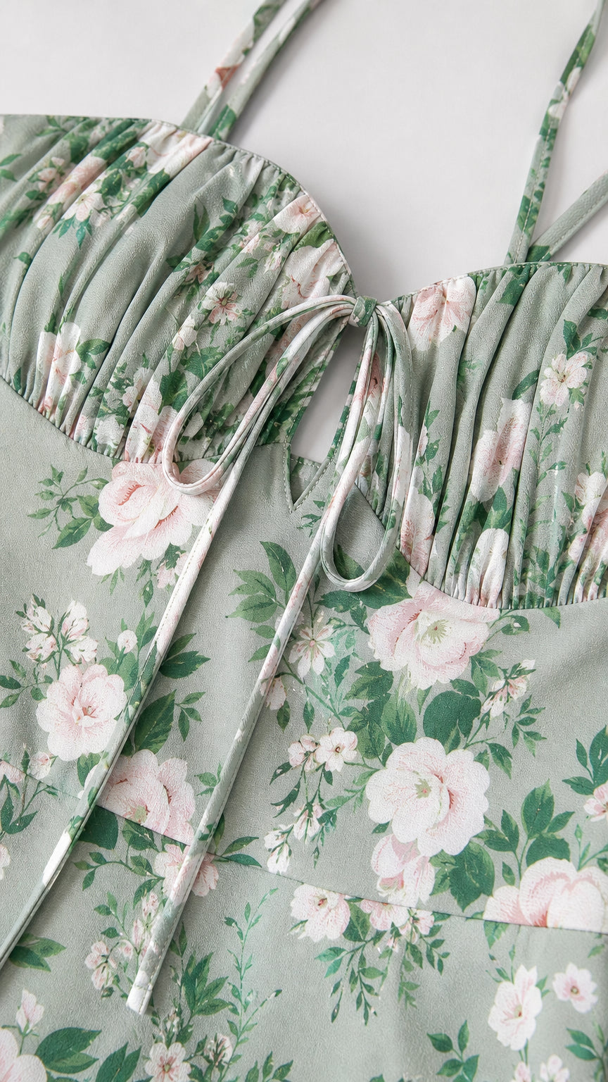 Close-up detail of gathered ruched sweetheart neckline and tie-front closure on floral fabric