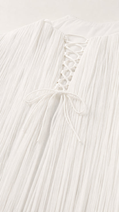 Close-up detail of lace-up back closure and fine pleated fabric texture