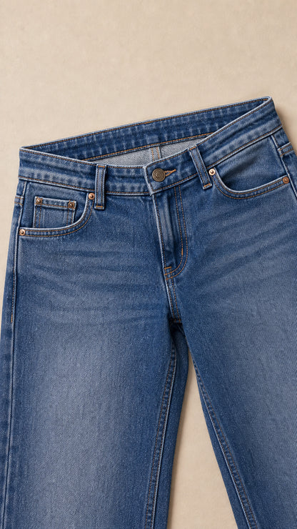 Close-up of the waistband, button closure, belt loops, front pocket, and denim texture