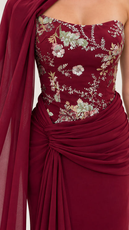 Close-up detail of burgundy floral embroidered bodice with side-gathered waist draping