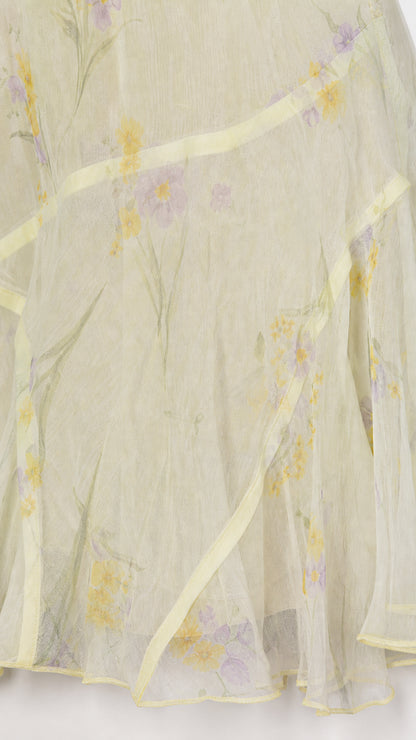 Close-up of light yellow floral fabric and ruffle hem detail