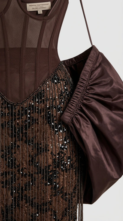 Close-up detail of structured corset boning, sequin embroidery, and puff sleeve