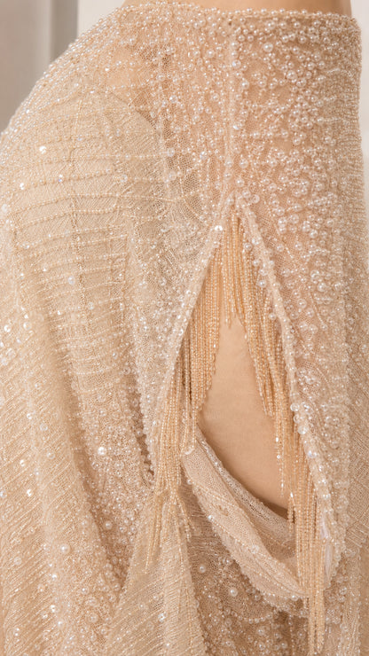 Close-up detail of champagne beaded mesh fabric and sleeve fringe trim