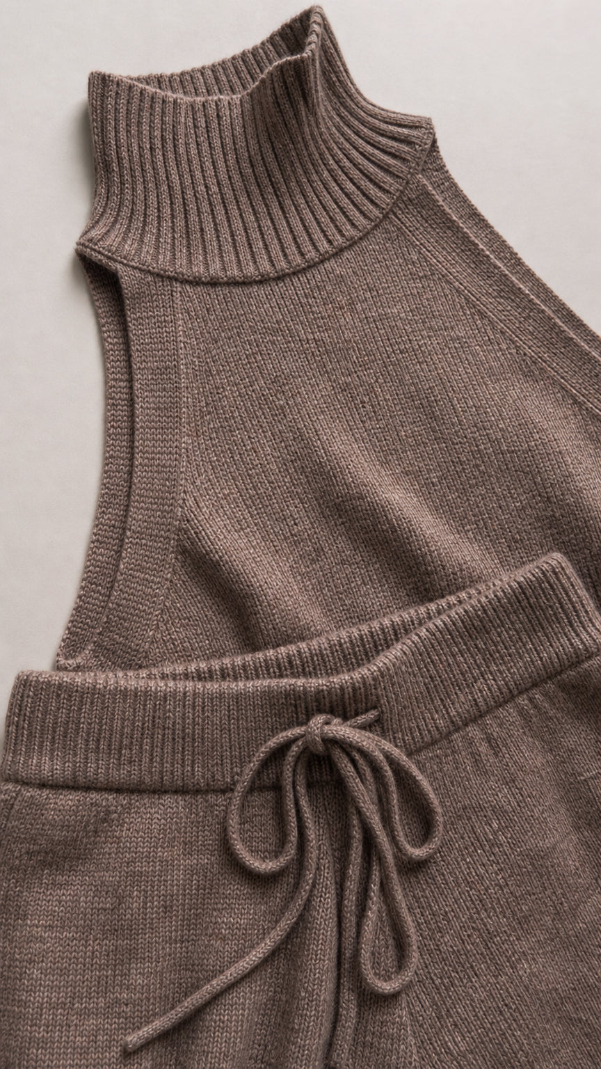 Close-up detail of ribbed mock neckline and drawstring waistband on knit fabric