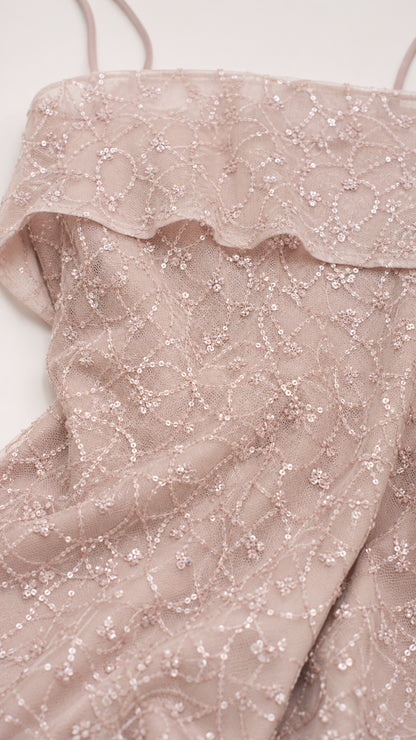 Close-up detail of dusty rose sequin lace fabric and folded neckline embellishment