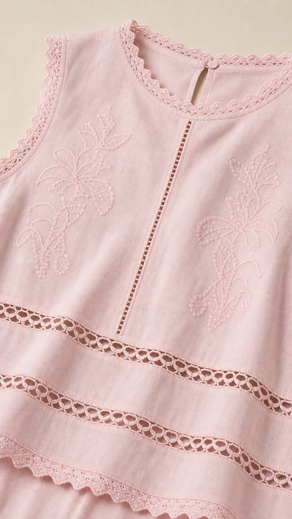 Close-up detail of embroidery and cutwork lace on pink top
