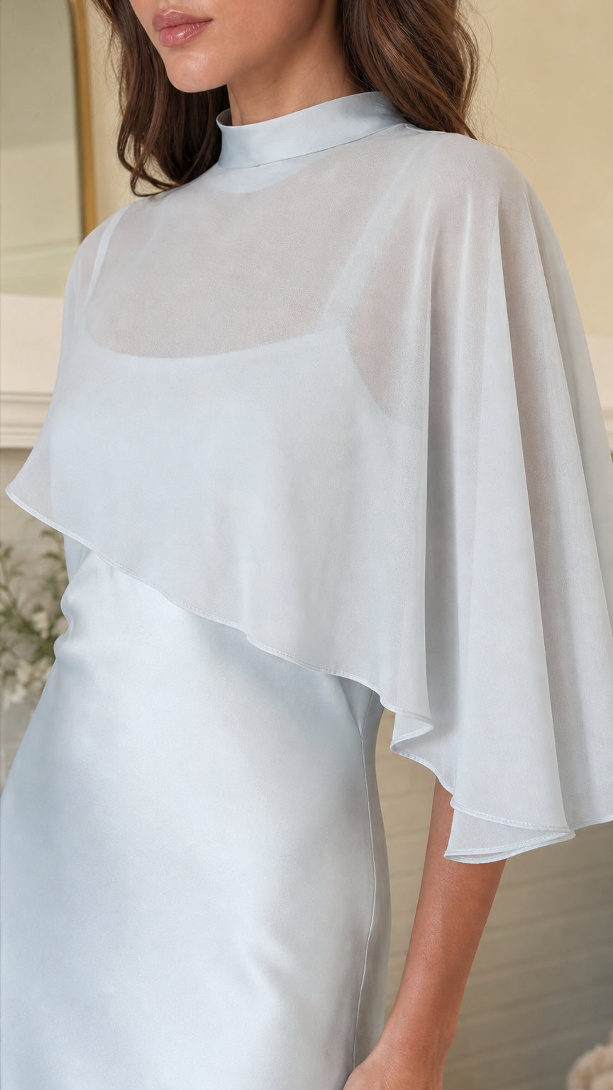 Close-up detail of sheer cape overlay and mock neck in Light Blue
