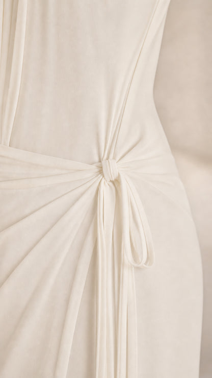 Close-up of the delicate side tie-waist detail on the white dress