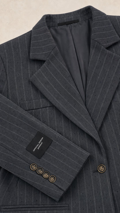 Close-up detail of charcoal pinstripe blazer notch lapel, sleeve buttons, and lining