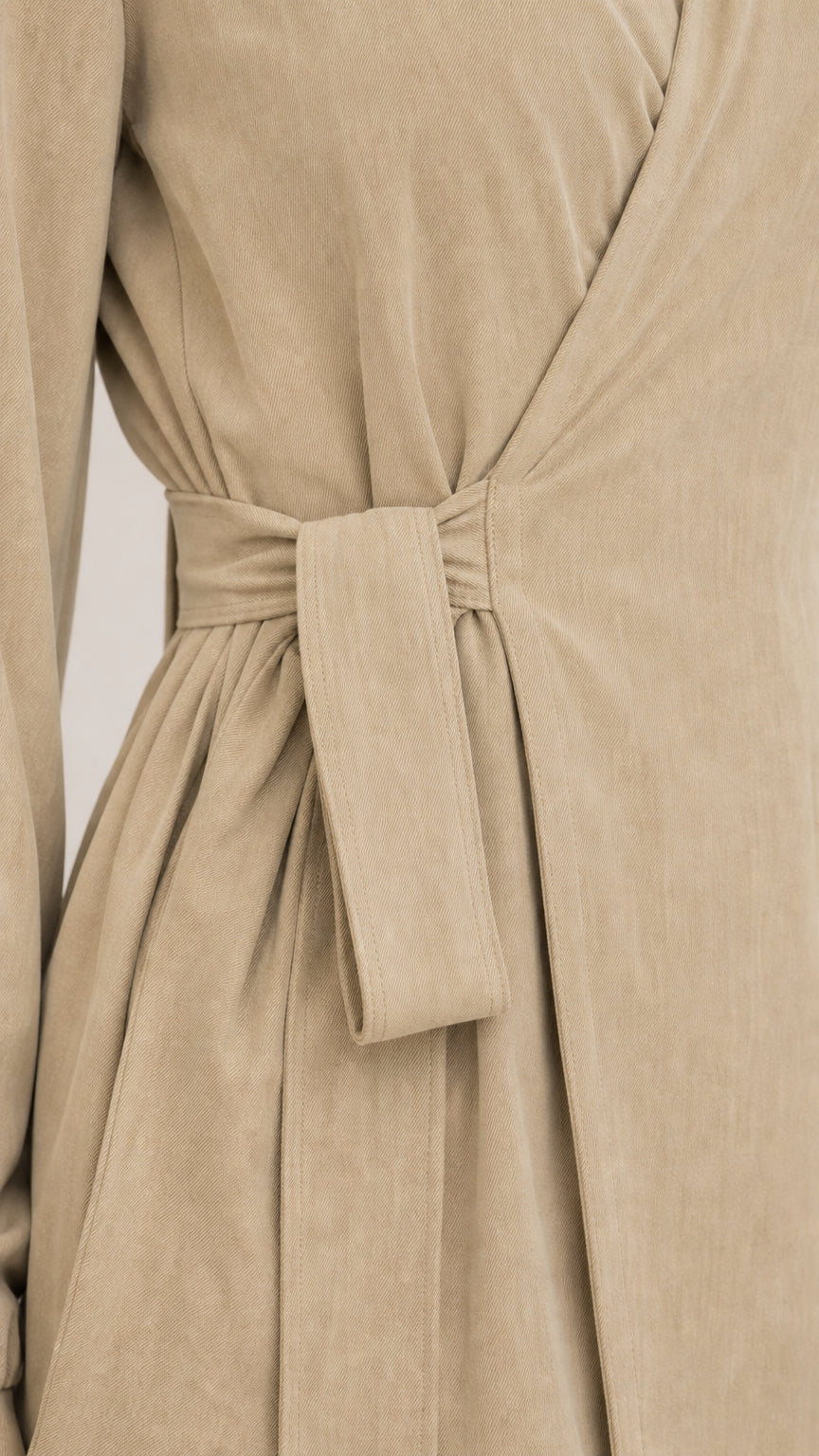 Close-up detail of the wrap-tie waist and lapel collar on khaki set